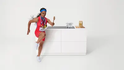 A dynamic woman in a sprinter pose and athletic wear poses on a modern 800 series induction cooktop, showcasing its sleek design and powerful performance.